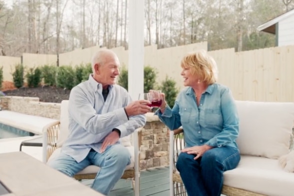 a retired couple enjoys wine in their outdoor living space